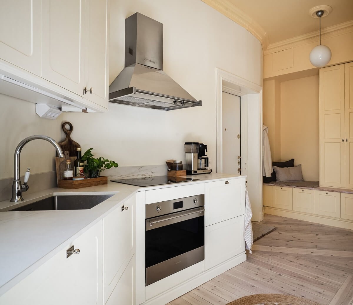 Warm Color Tones in a Scandinavian Apartment 7 white kitchen with open floorplan to hallway
