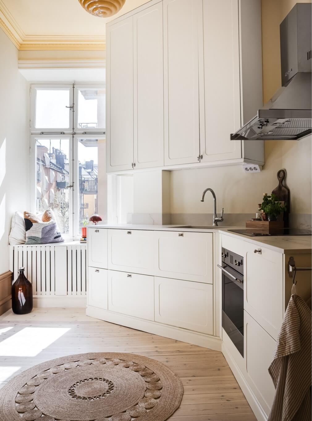 Warm Color Tones in a Scandinavian Apartment 6 white kitchen with round jute rug