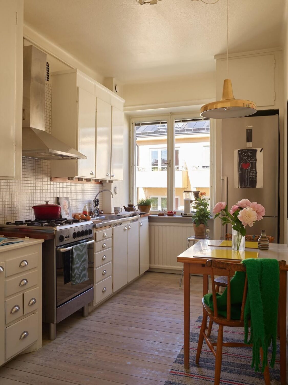 A Vintage Apartment with a Vibrant Blue Bedroom 8 white kitchen with table and yellow lamp