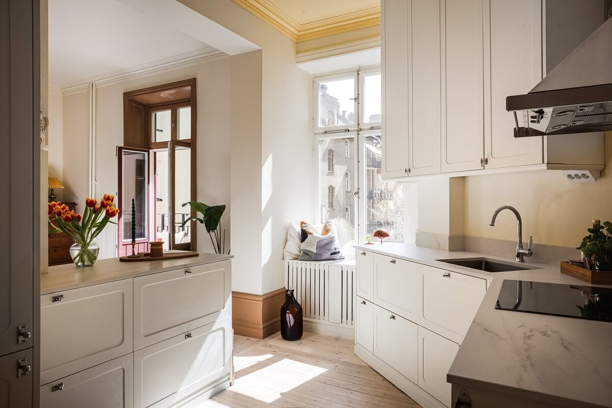 Warm Color Tones in a Scandinavian Apartment 5 white ktichen with yellow ceiling