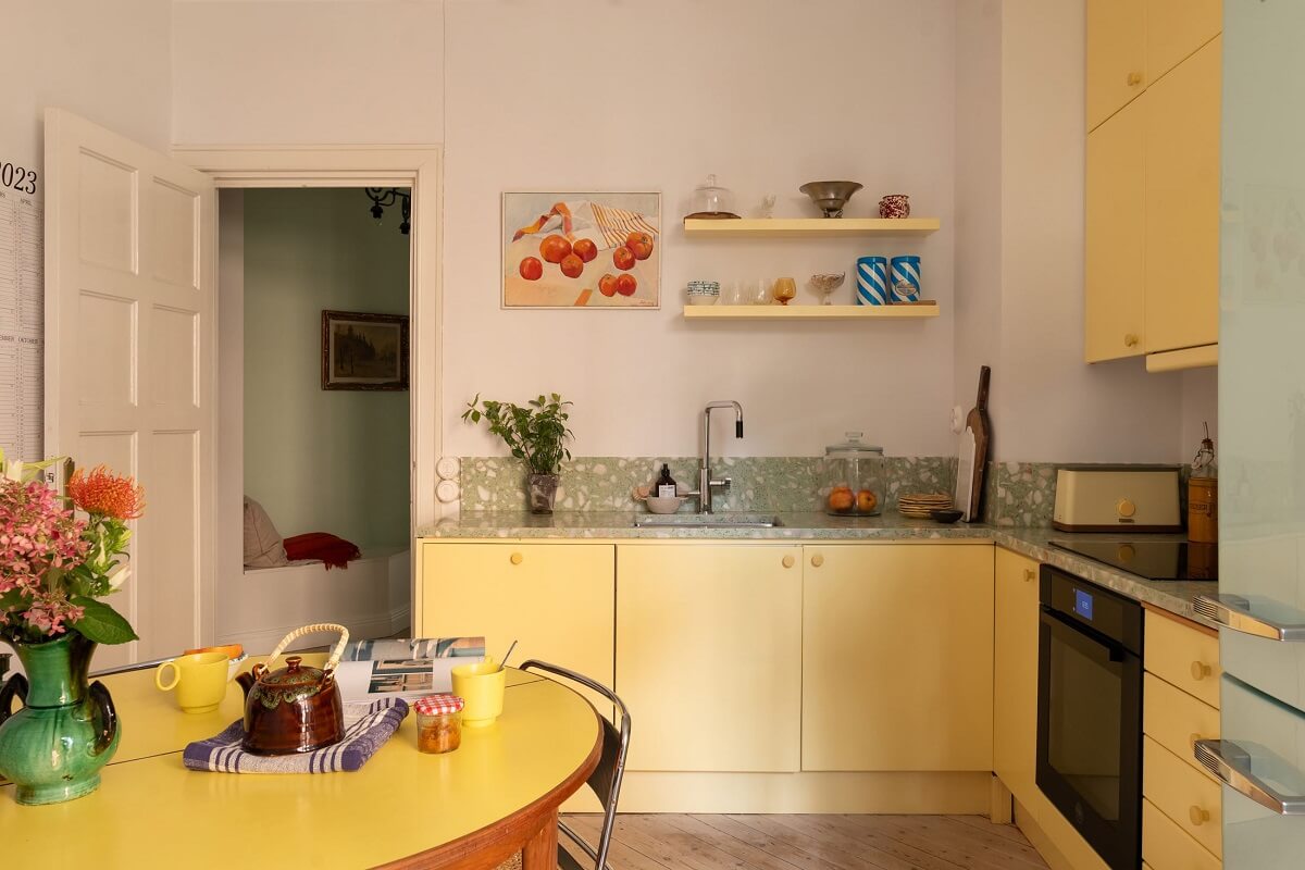 A Swedish Apartment with a Yellow Kitchen 3 yellow kitchen cabinets with shelves