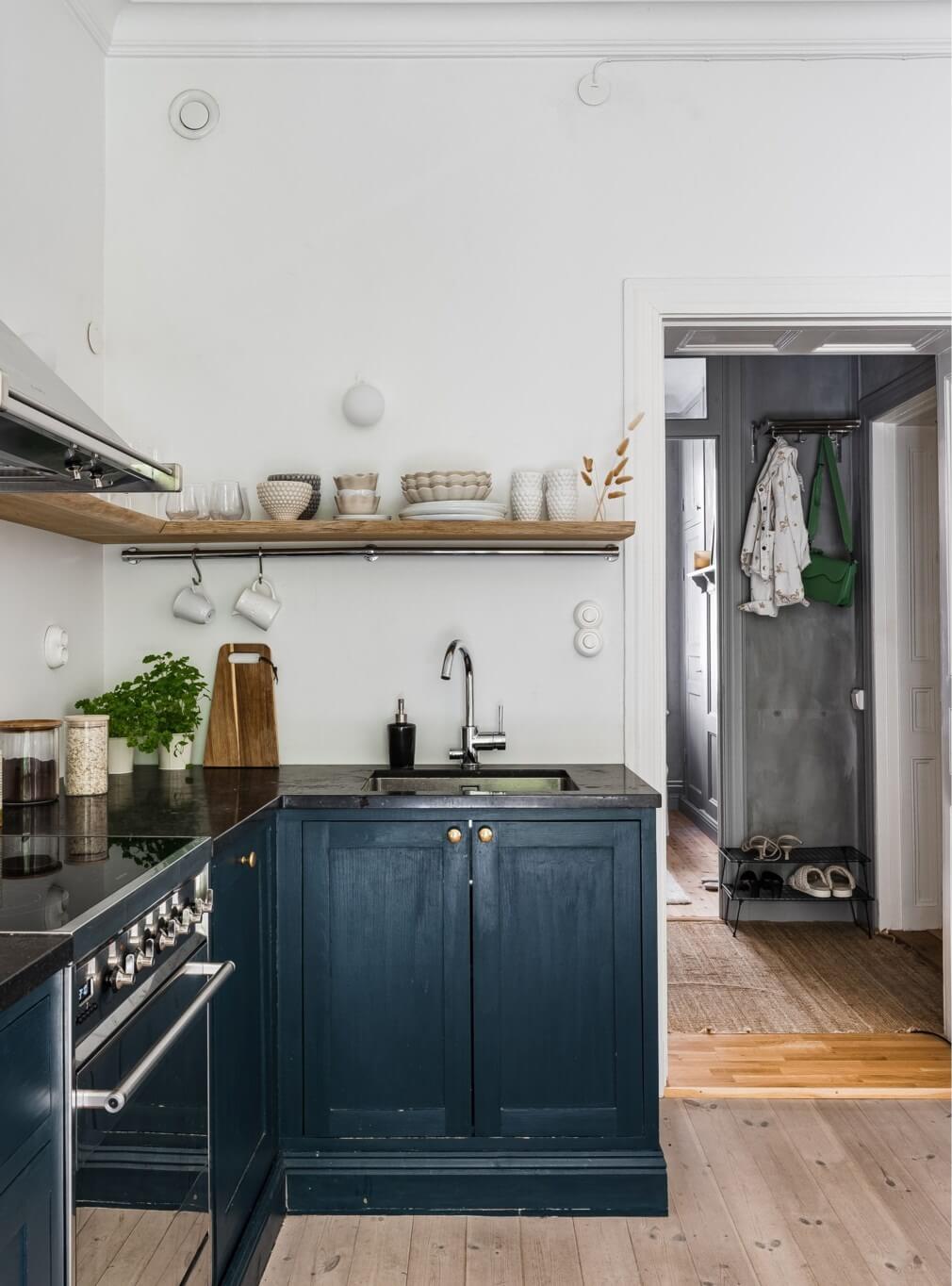 A Small Stockholm Apartment with a Gray Bedroom & Sunny Balcony 7 dark blue kitchen with shelf