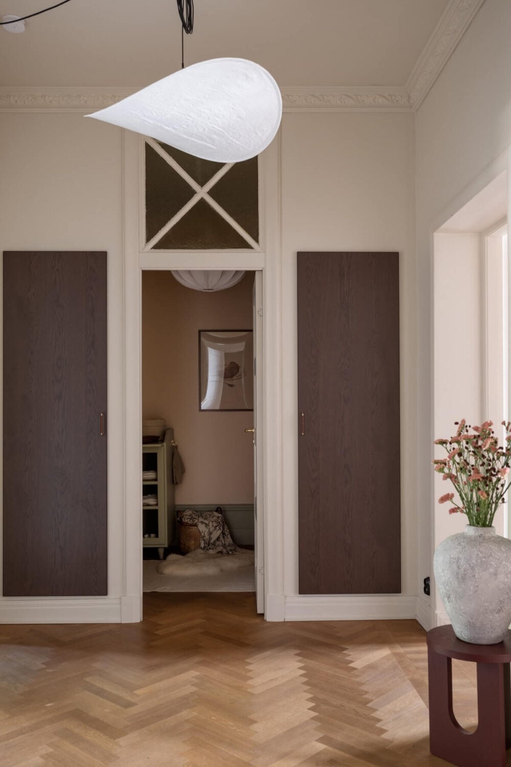 Warm Colors and Painted Ceilings in a Swedish Apartment 20 hallway with built in closets and herringbone floor