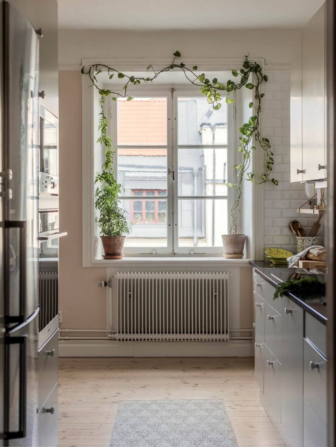 A Light Atmosphere and Wallpapers in a Swedish Apartment 9 kitchen with plants around window