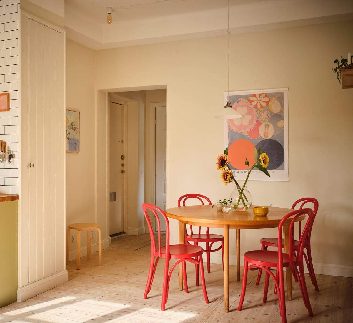 A Light Apartment with a Sage Green Kitchen 10 kitchen with round dining table with red chairs A Light Apartment with a Sage Green Kitchen