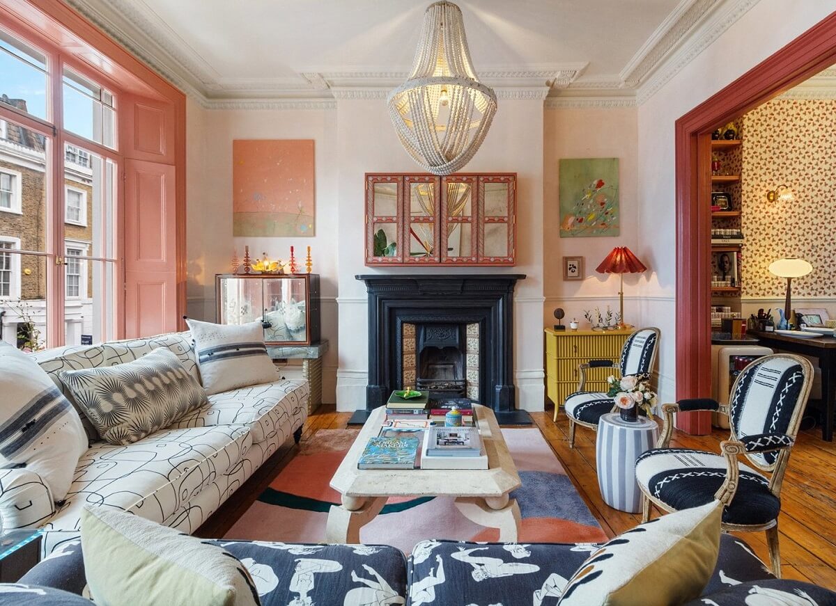Limewash Paint and Artisan Wallpaper in a London Townhouse 3 living room with black fireplace pink woodwork and graphic sofas