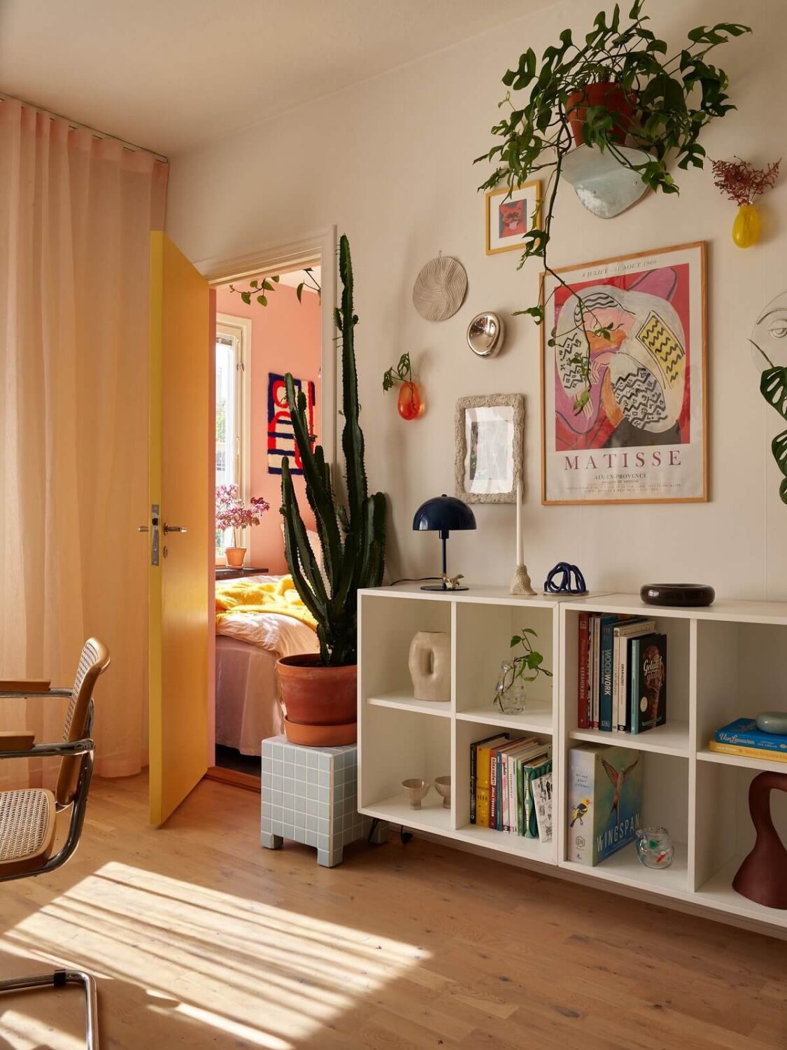 A Small Light Filled Apartment with Plants and Color 7 living room with plants and open cabinets