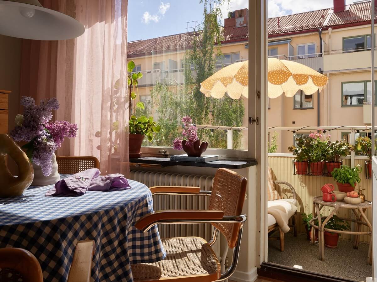 A Small Light Filled Apartment with Plants and Color 9 living room with round dining table and balcony