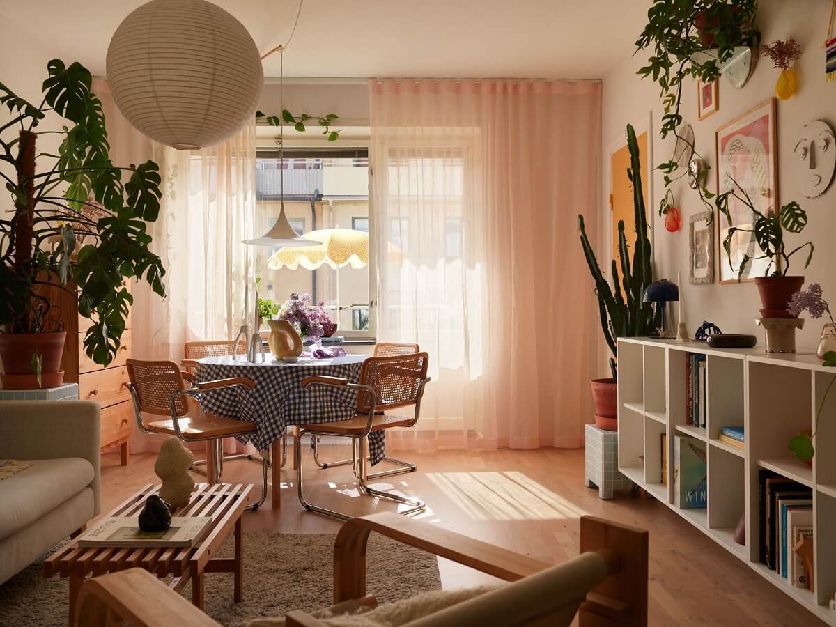 A Small Light Filled Apartment with Plants and Color 2 natural light living room with dining table and open cabinets nordroom