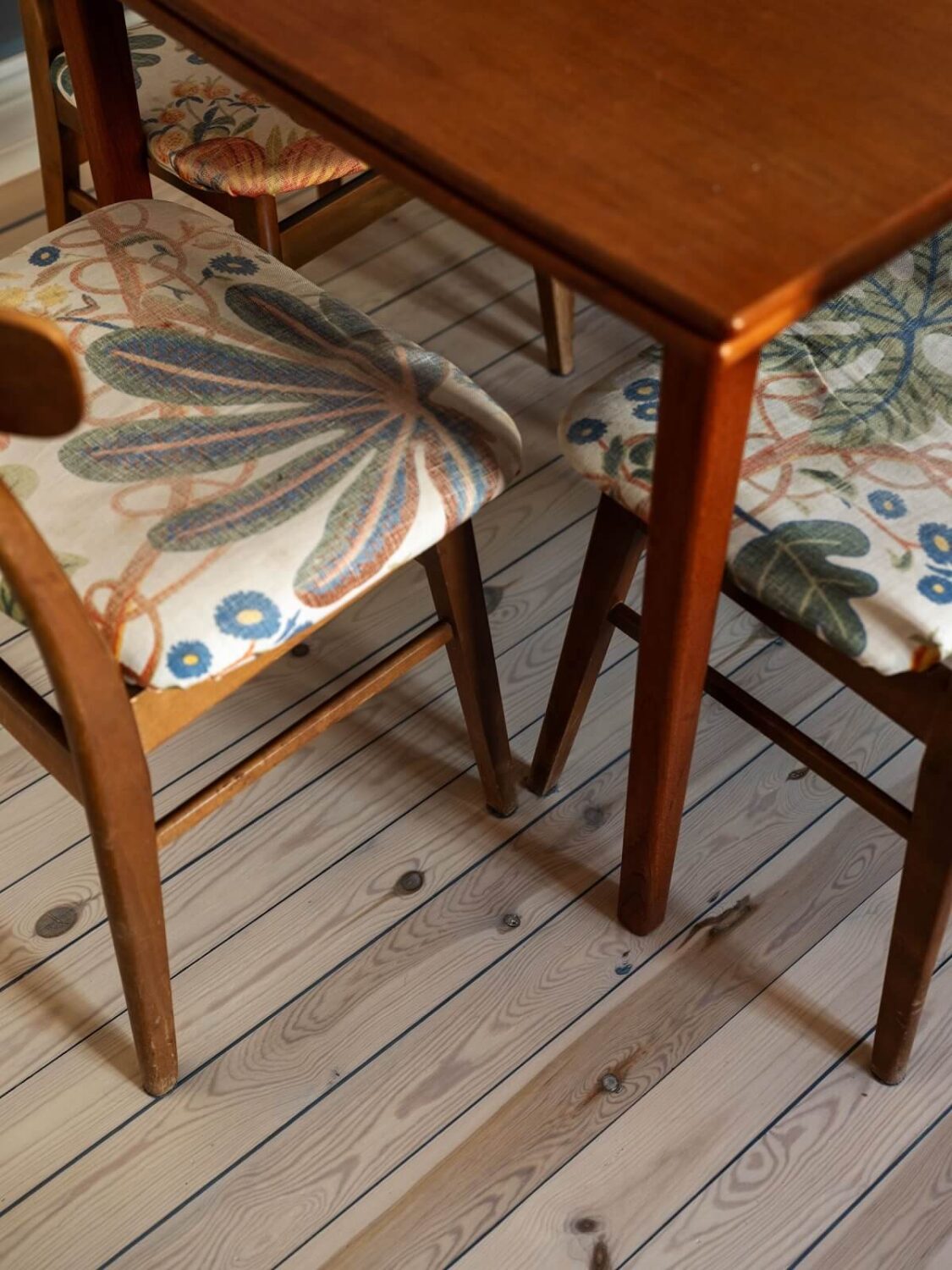 A Light Apartment with a Sunny Balcony 5 patterned dining chairs and wooden floor