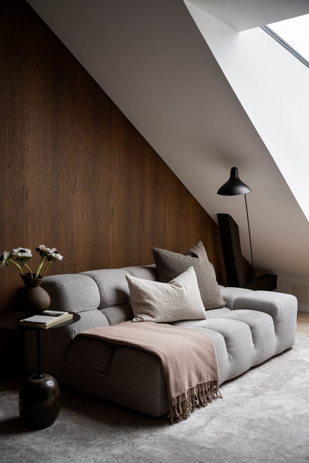 A Stylish Scandinavian Duplex with Custom-Made Cabinets 14 sitting room with slanted ceiling and wooden feature wall