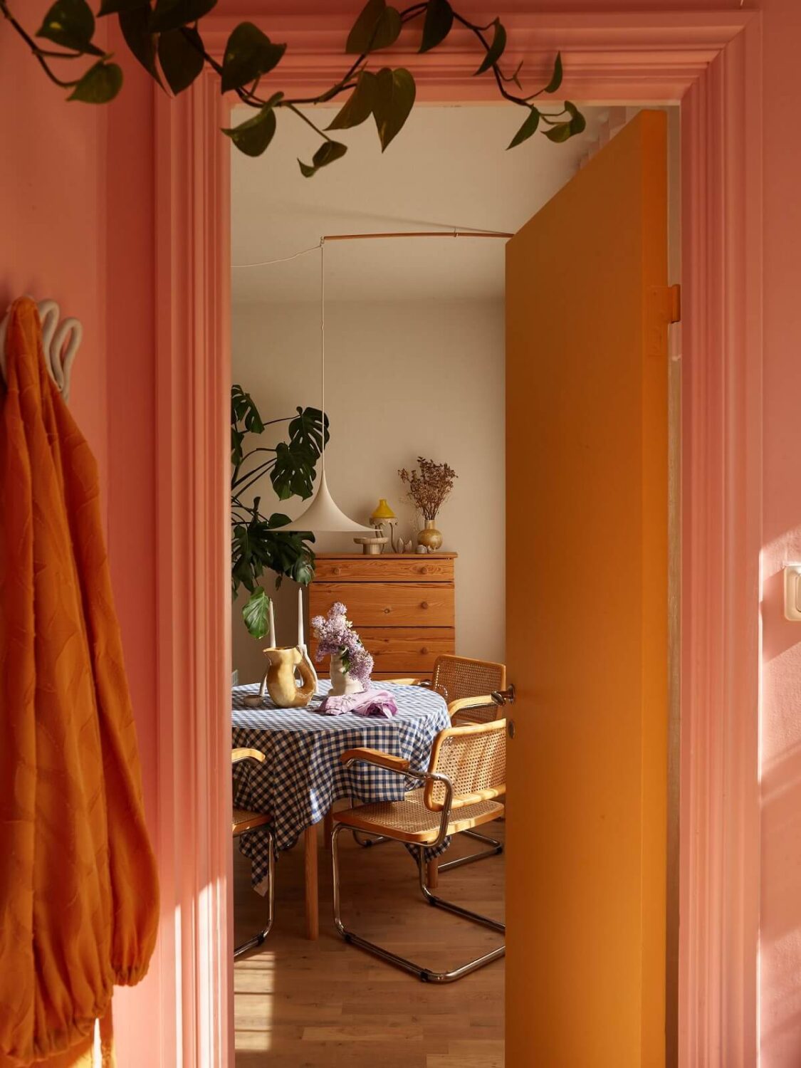 A Small Light Filled Apartment with Plants and Color 12 view into living room with round table