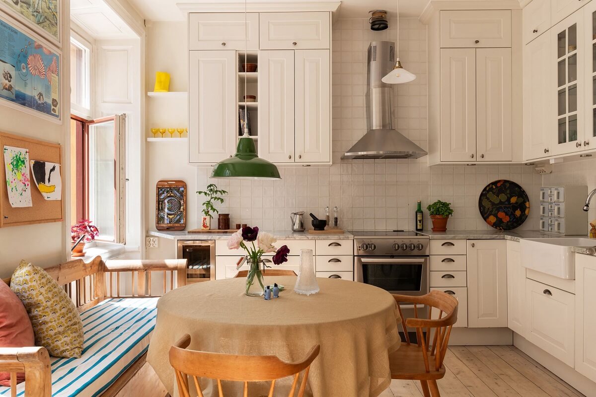 Light and Charming Rooms in a Historic Stockholm Apartment 9 white kitchen with round table and bench nordroom