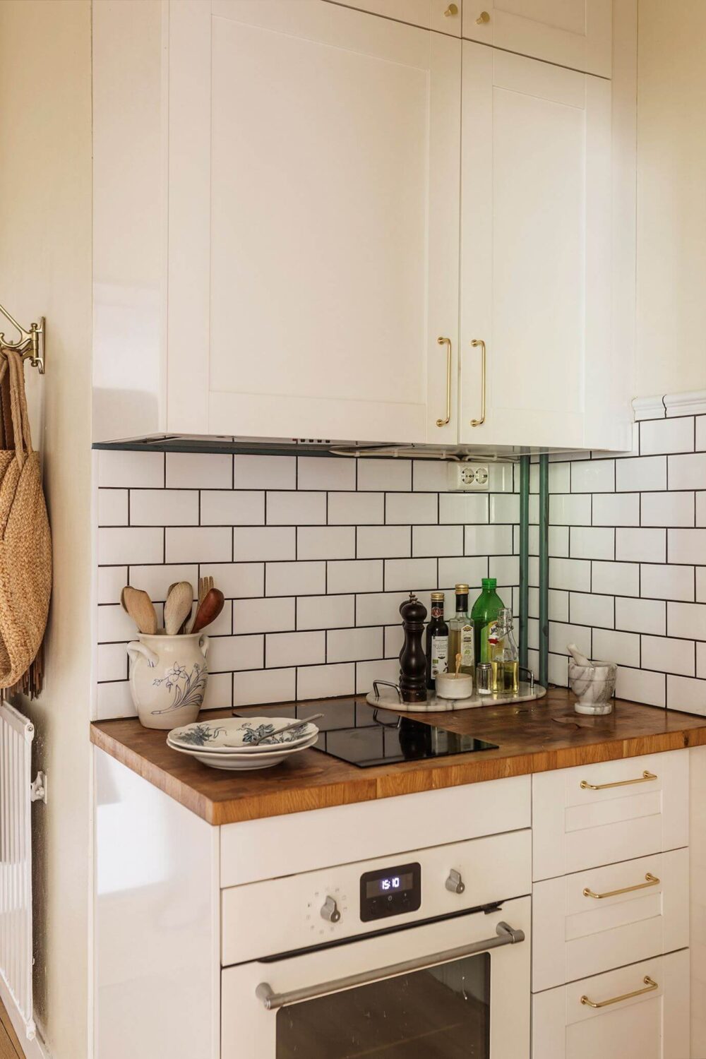 A Charming Studio Apartment with a Loft Bed 10 white kitchen with subway tiles