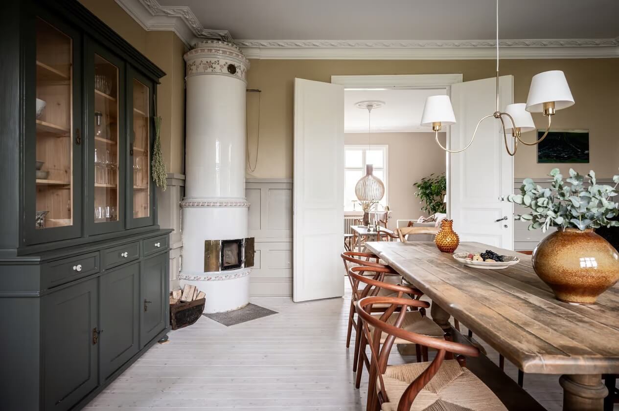 Original Charm in a Light Green Swedish Country House 8 wooden dining table and fireplace