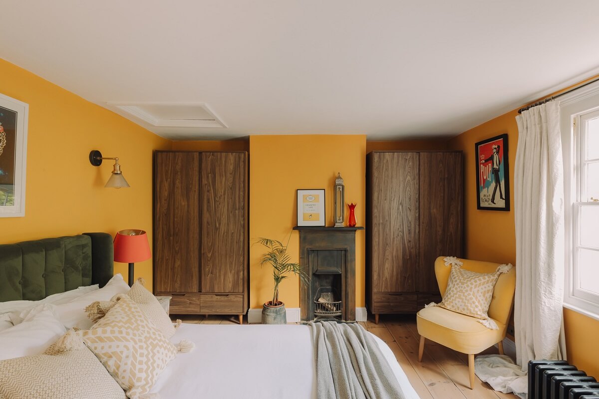 Colorful Rooms in an Elegant Georgian Home in England 19 yellow bedroom with green velvet bed headboard