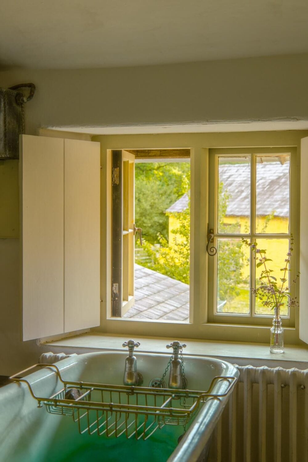 A Yellow Farmhouse with Bold Color Pops in Wales 24 bathroom with bath under window