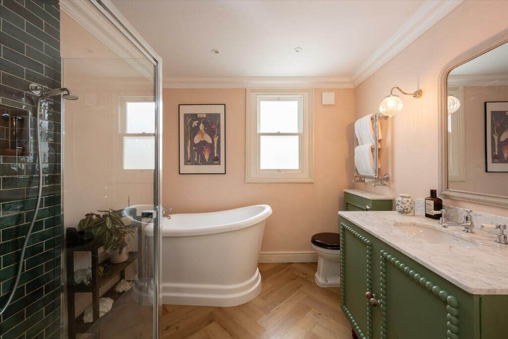 Cottage-style Interiors in a London Family Home 14 bathroom with peach walls green shower tiles and green vanity