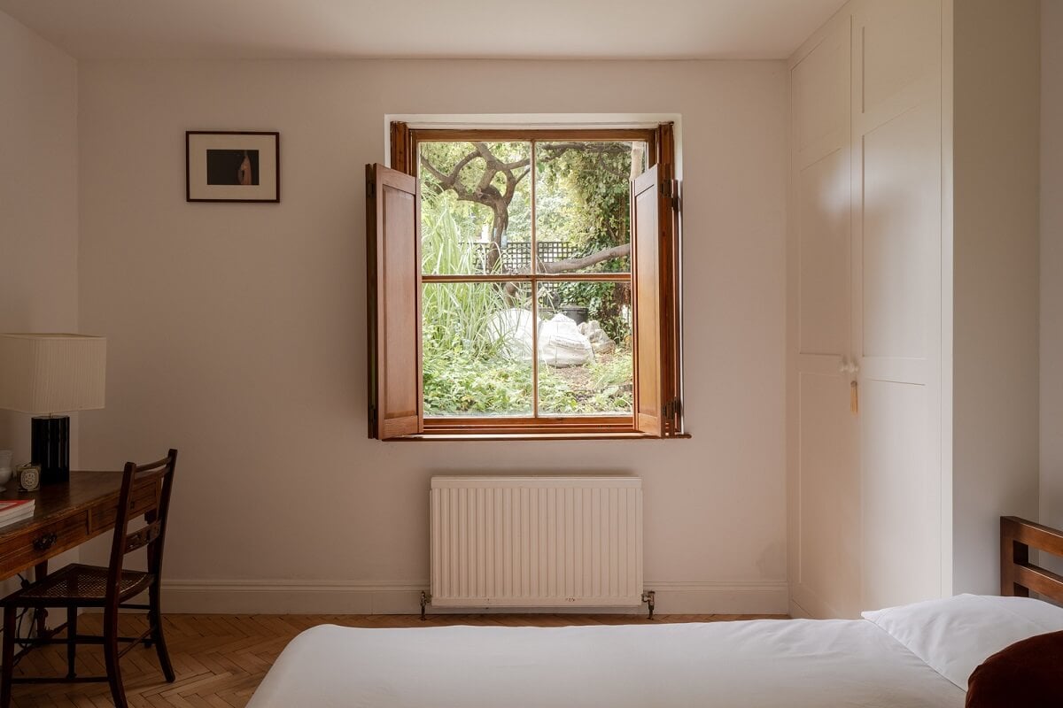 Pared Back Interiors and Light-Filled Spaces in a London Apartment 11 bedroom with wooden window shutters