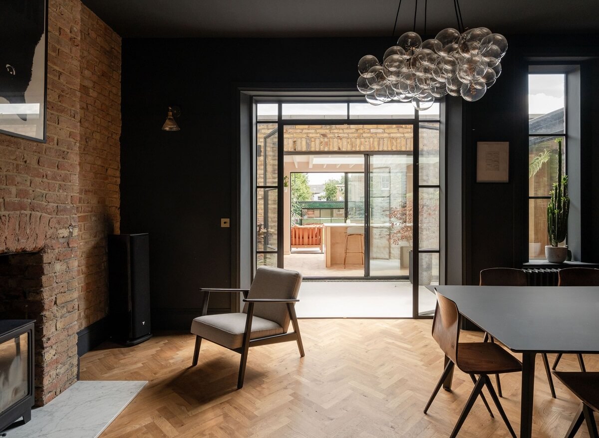 A Stunning Color Palette in an Extended Edwardian House in London 6 black dining room with exposed brick wall nordroom
