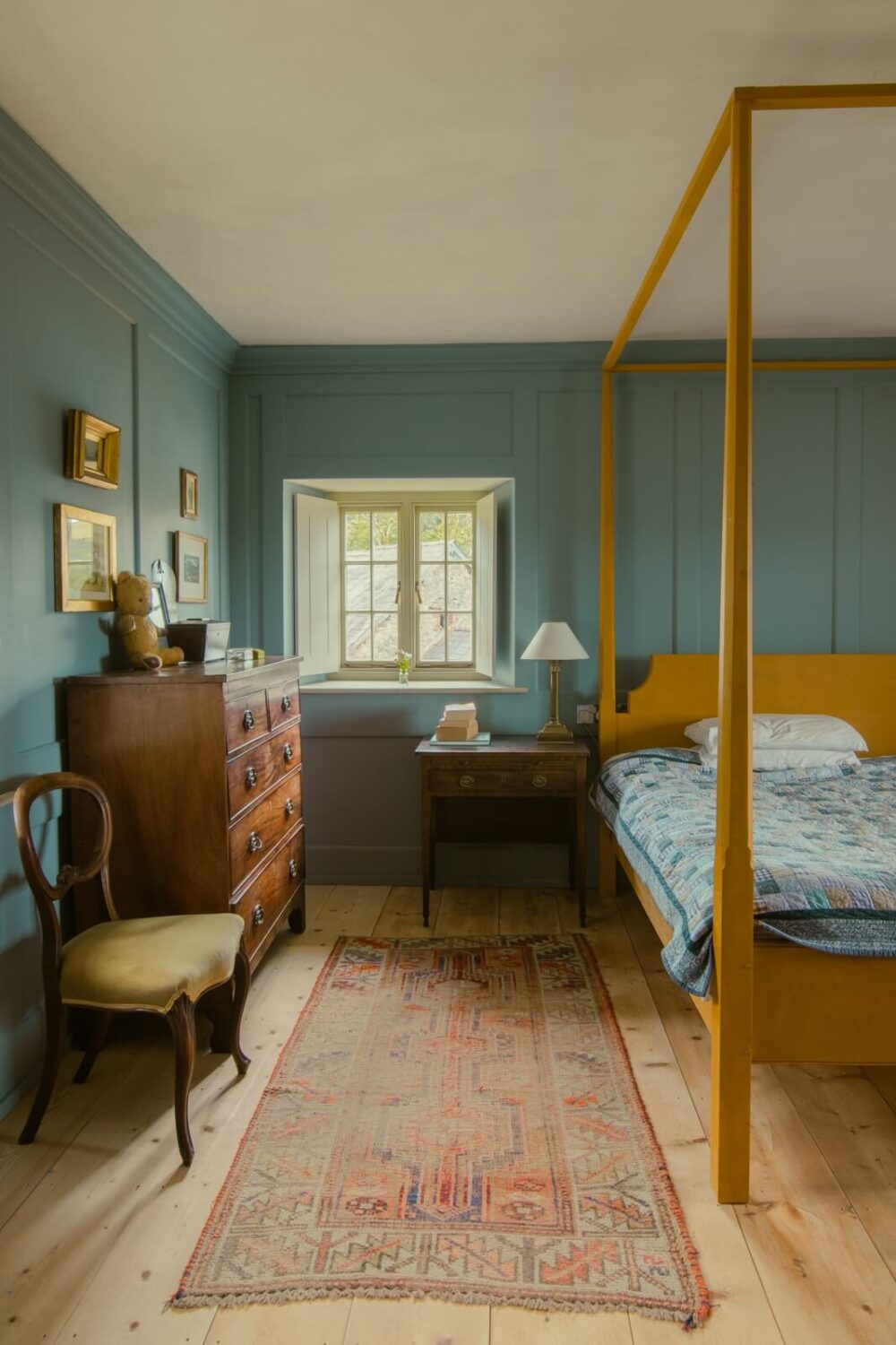 A Yellow Farmhouse with Bold Color Pops in Wales 21 blue bedroom with yellow canopy bed