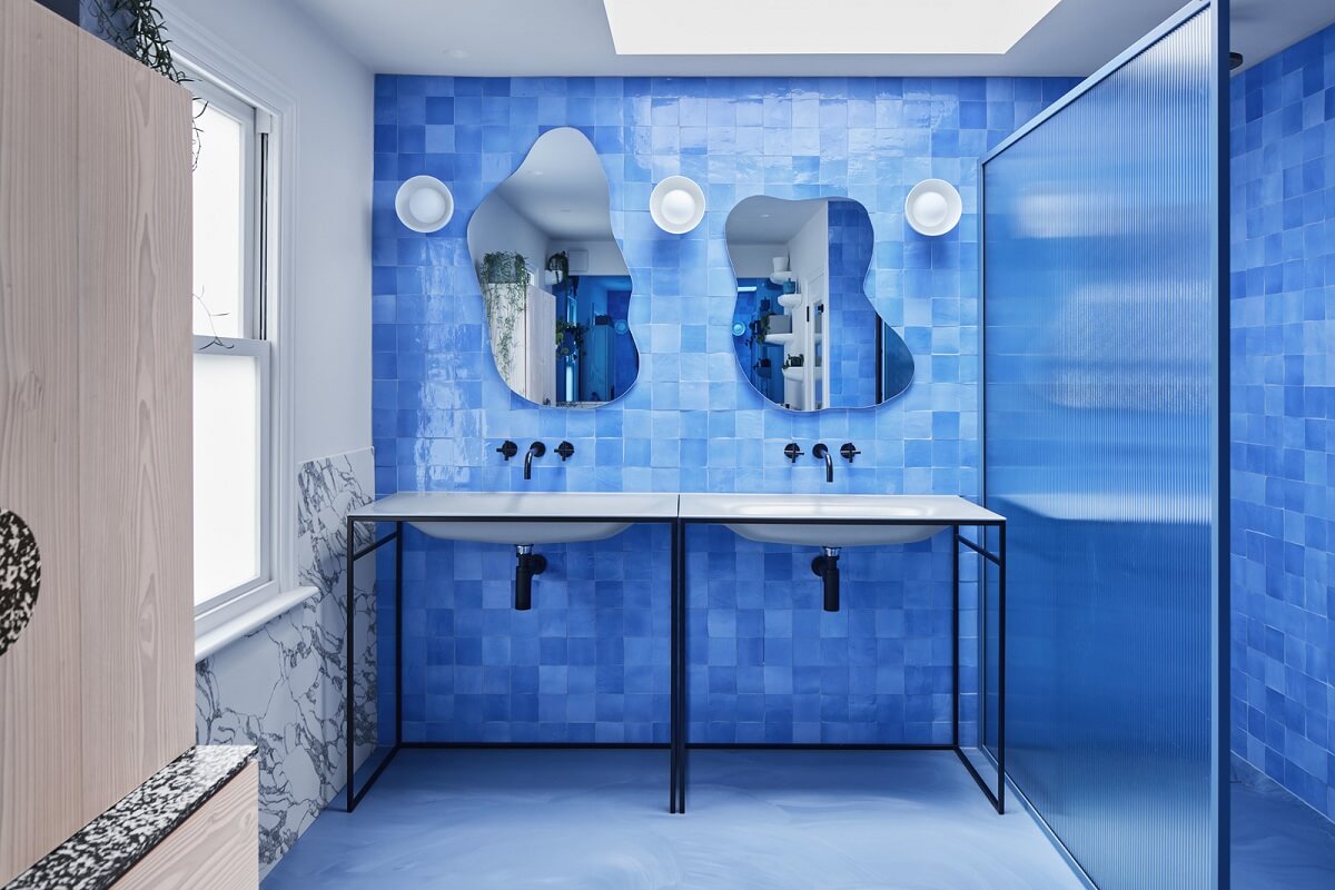 A London Family Home Decorated in Pastel Colors 23 blue tiles double sink with wavy mirrors nordroom