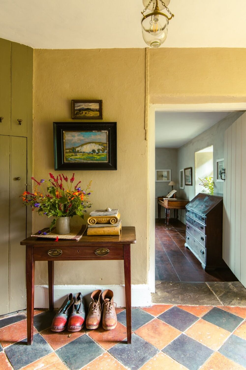 A Yellow Farmhouse with Bold Color Pops in Wales 3 checkerboard floor tiles hallway