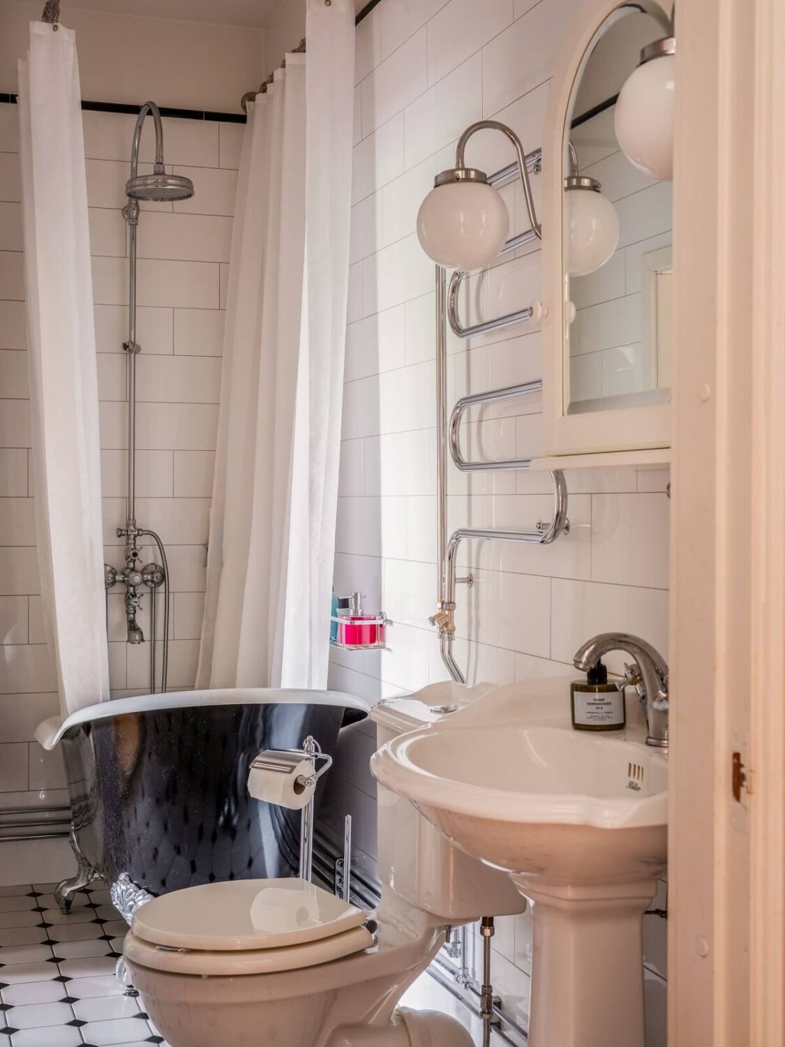 Antique Furniture and Arched Windows in a Stockholm Apartment 20 classic bathroom with black tub