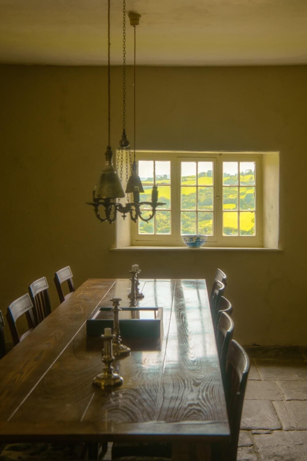 A Yellow Farmhouse with Bold Color Pops in Wales 12 dining room wooden table stone floor