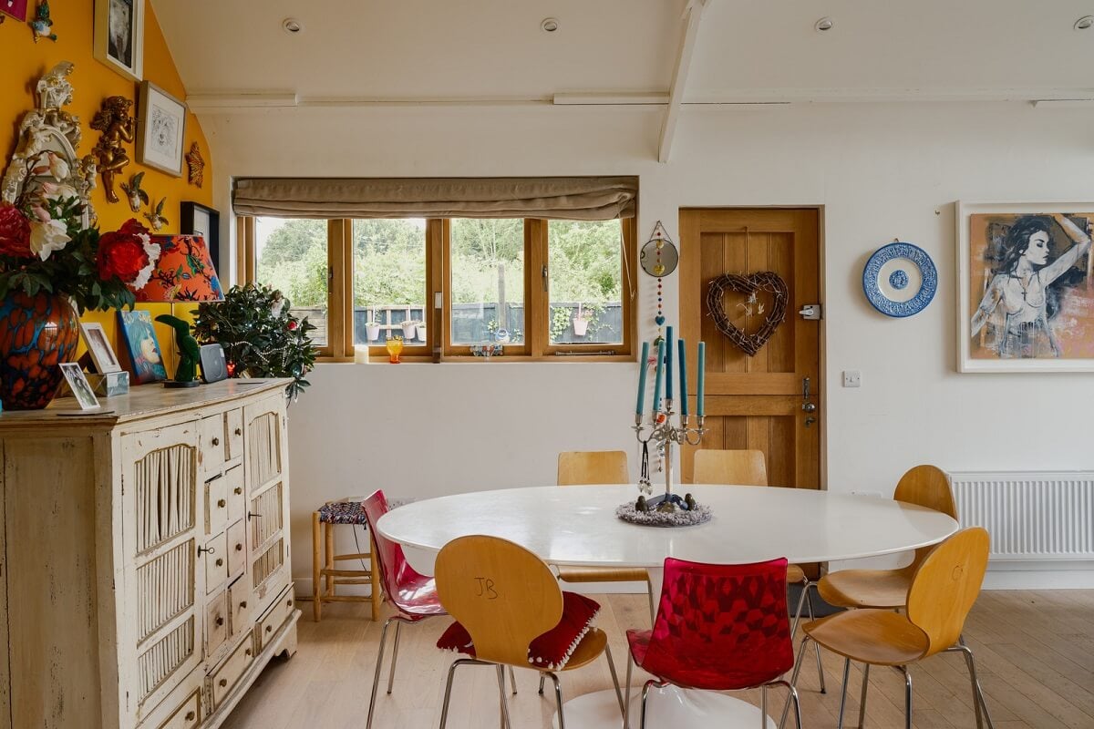 A Black Barn House with Boho Interiors and Breathtaking Views 7 dining space colorful chairs
