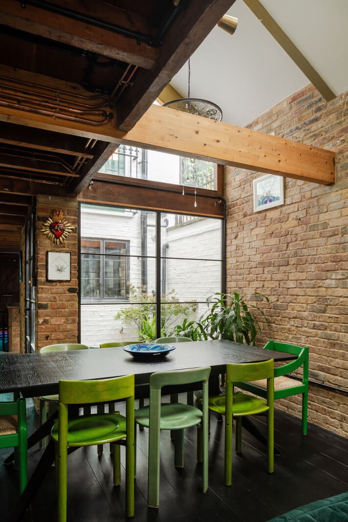 Exposed Materials and Green Tones in a London Stable Conversion 4 dining space pitched ceiling exposed brick wall