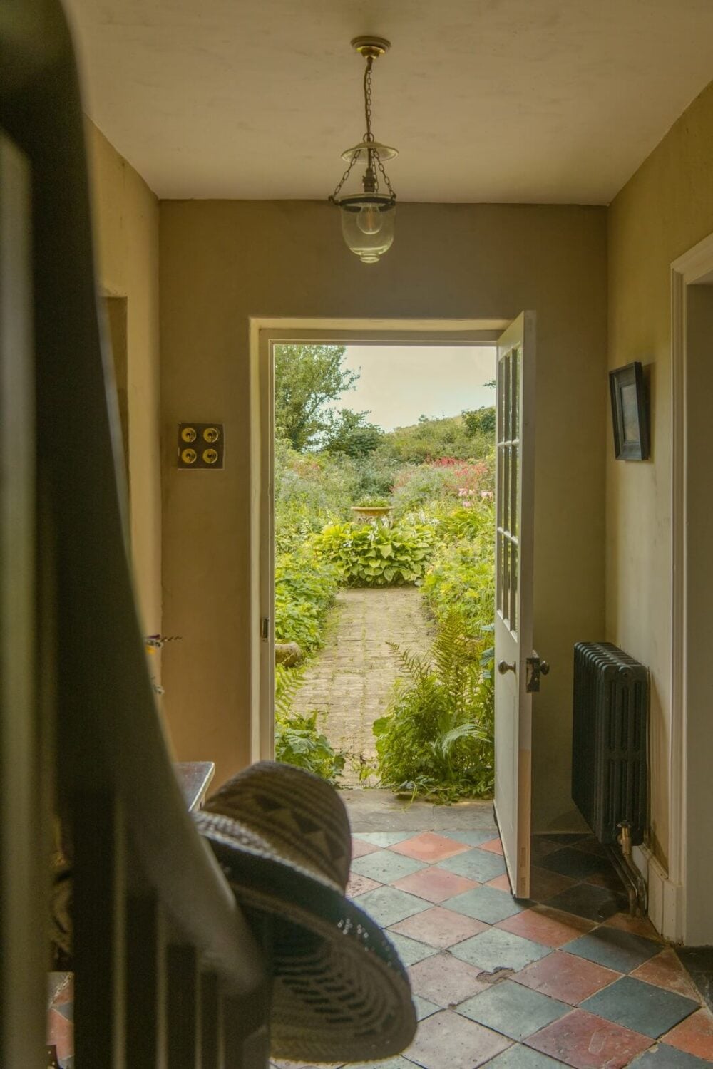 A Yellow Farmhouse with Bold Color Pops in Wales 4 farmhouse hall with checkerboard tiles