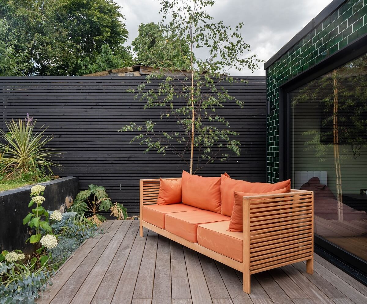 A Stunning Color Palette in an Extended Edwardian House in London 33 garden seating with orange cushions