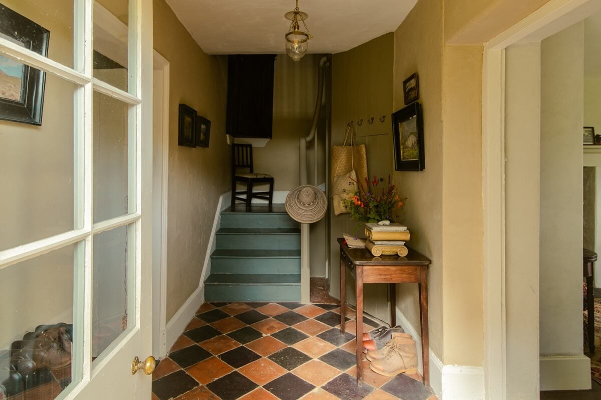 A Yellow Farmhouse with Bold Color Pops in Wales 2 hallway with checkerboard floor