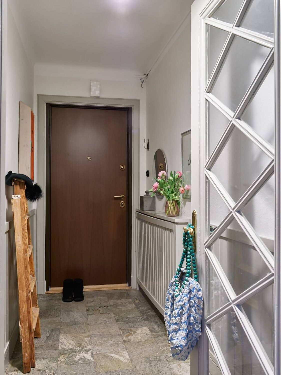 A Charming 1920s Apartment with a Green Bedroom 16 hallway with gray floor tiles