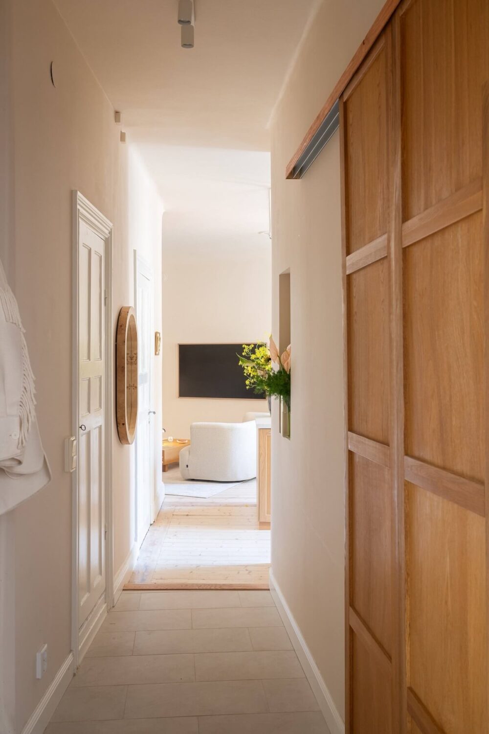 An Elegant Small Renovated Apartment in Stockholm 21 hallway with oak sliding door