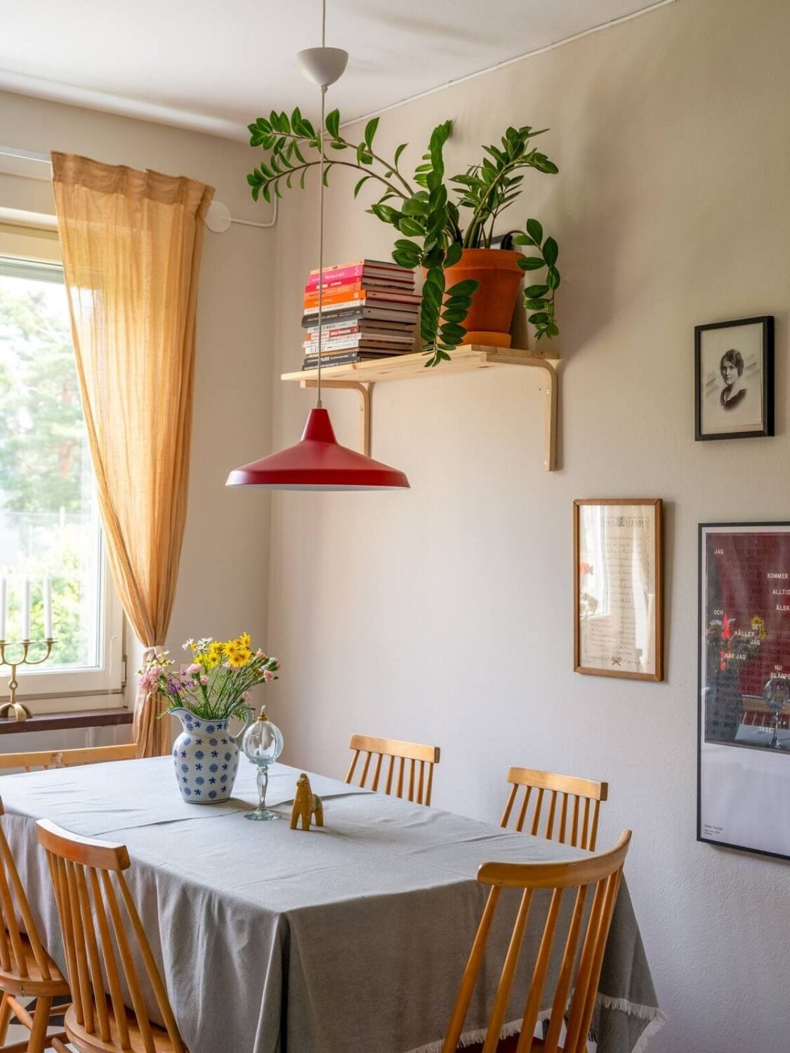 A Studio Apartment with Light Pink Walls and Vintage Furniture 16 kitchen dining table red pendant