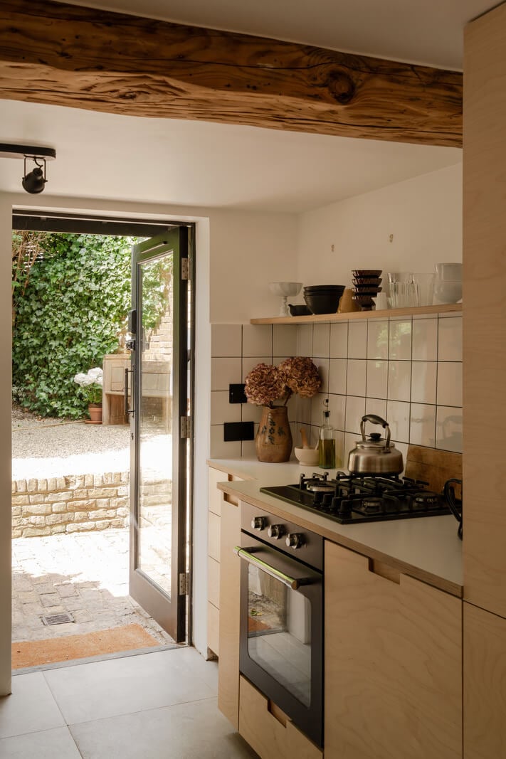 Pared Back Interiors and Light-Filled Spaces in a London Apartment 8 kitchen plywood cabinets wooden beam