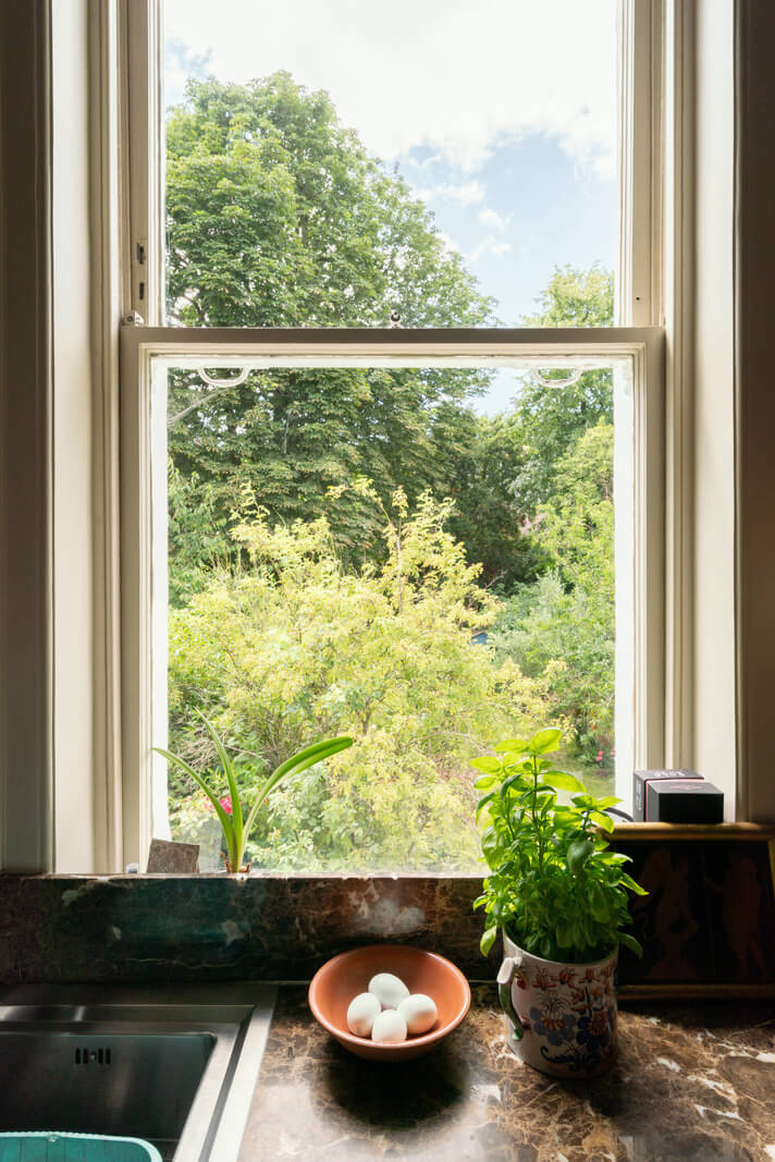 A Moody Color Palette and Eclectic Interiors in a London Apartment 10 kitchen window view