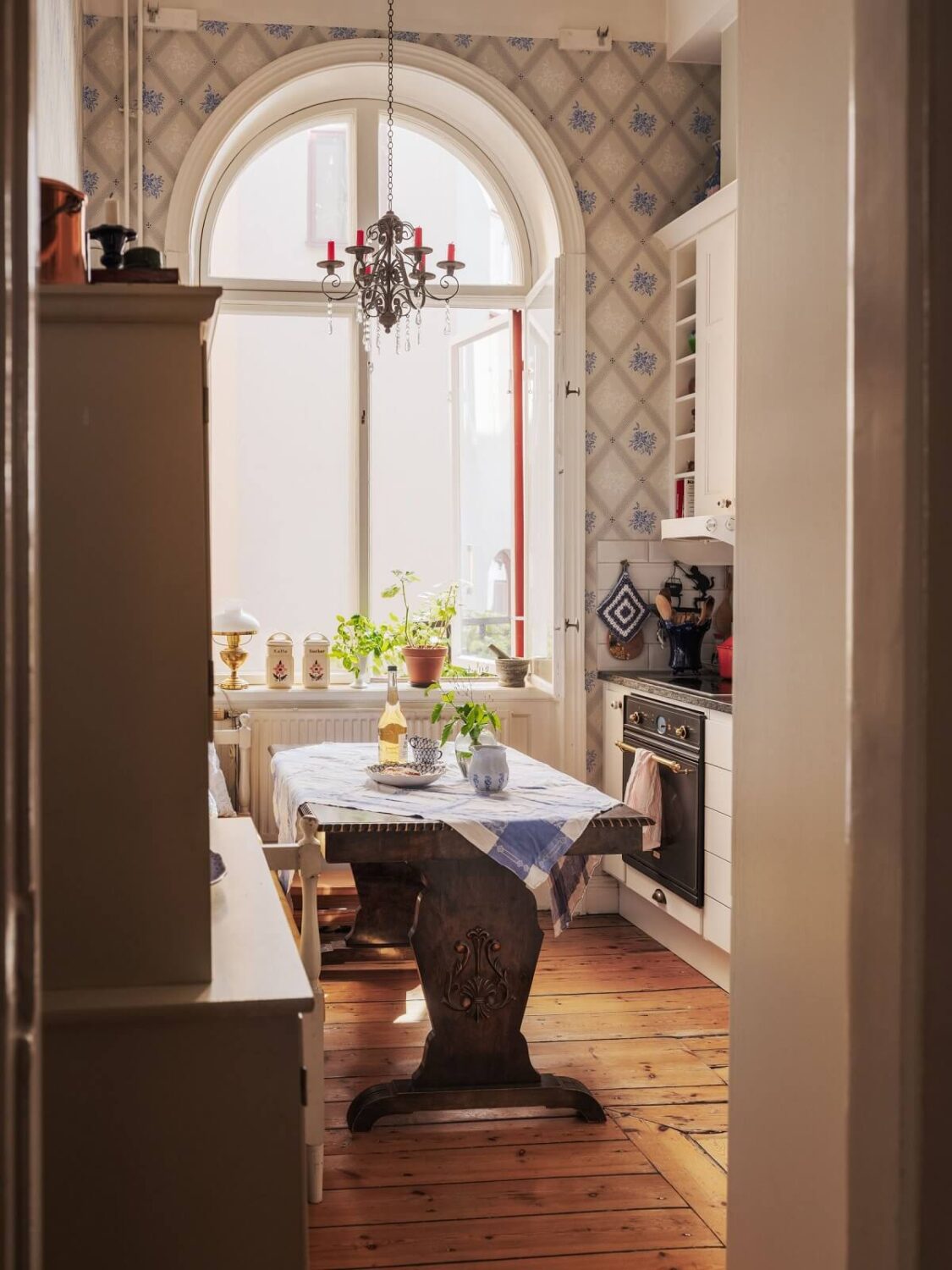 Antique Furniture and Arched Windows in a Stockholm Apartment 9 kitchen with arched window and wooden table nordroom