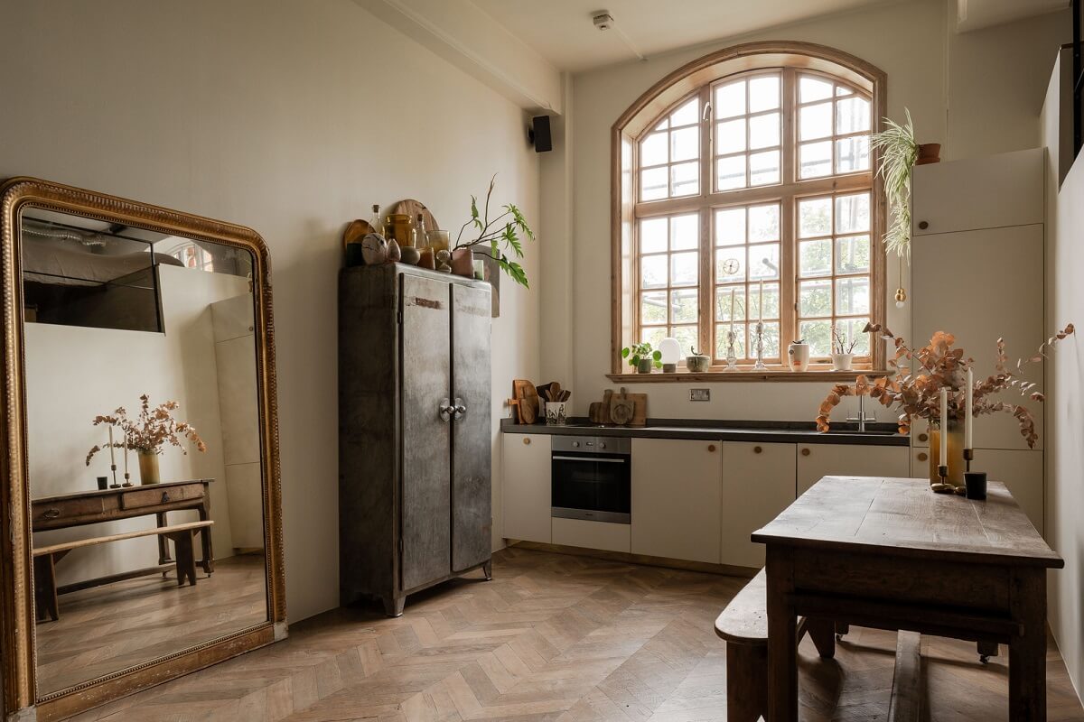 A London Loft in a Former Victorian School Building 5 kitchen with large arched window and mirror