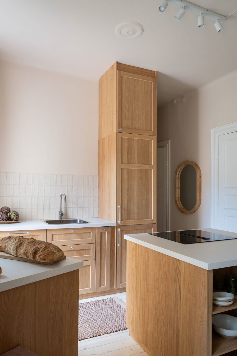 An Elegant Small Renovated Apartment in Stockholm 5 kitchen with oak cabinets and beige tiles