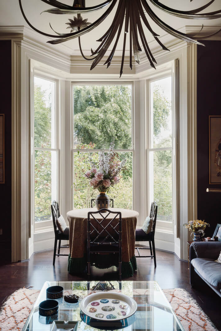 A Moody Color Palette and Eclectic Interiors in a London Apartment 2 living room bay indow with round dining table nordroom