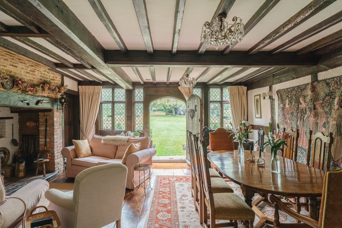 Magnificent Period Features in an English Tudor House 2 living room with brick fireplace dining table and wooden beams