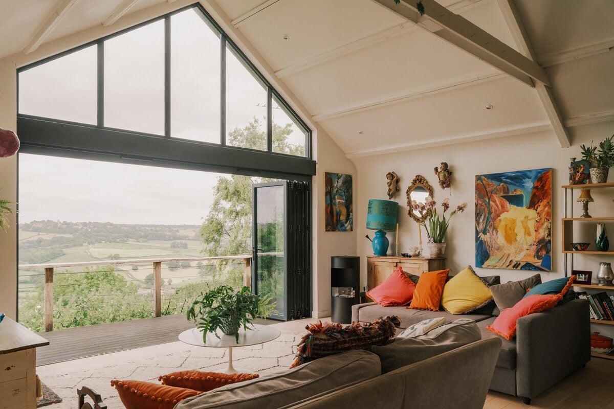A Black Barn House with Boho Interiors and Breathtaking Views 3 living room with folding glass doors
