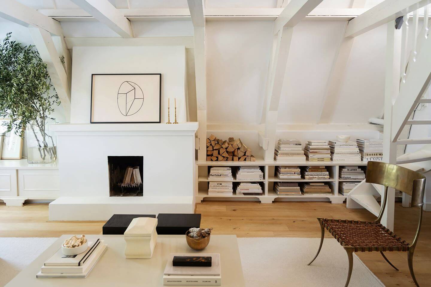 An Apartment with High Pitched Ceilings in an Amsterdam Canal House 3 minimalistic white living room with fireplace shelves and pitched ceiling nordroom