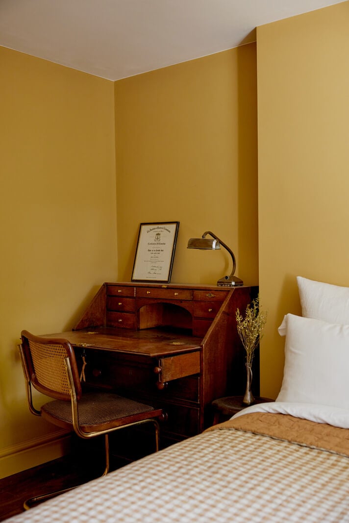 ochre yellow walls bedroom with vintage desk