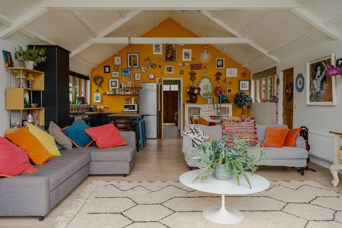 A Black Barn House with Boho Interiors and Breathtaking Views 2 open plan living space with pitched ceiling and yellow wall nordroom