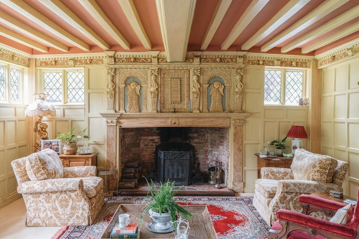 Magnificent Period Features in an English Tudor House 11 sitting room with fireplace and pink ceiling