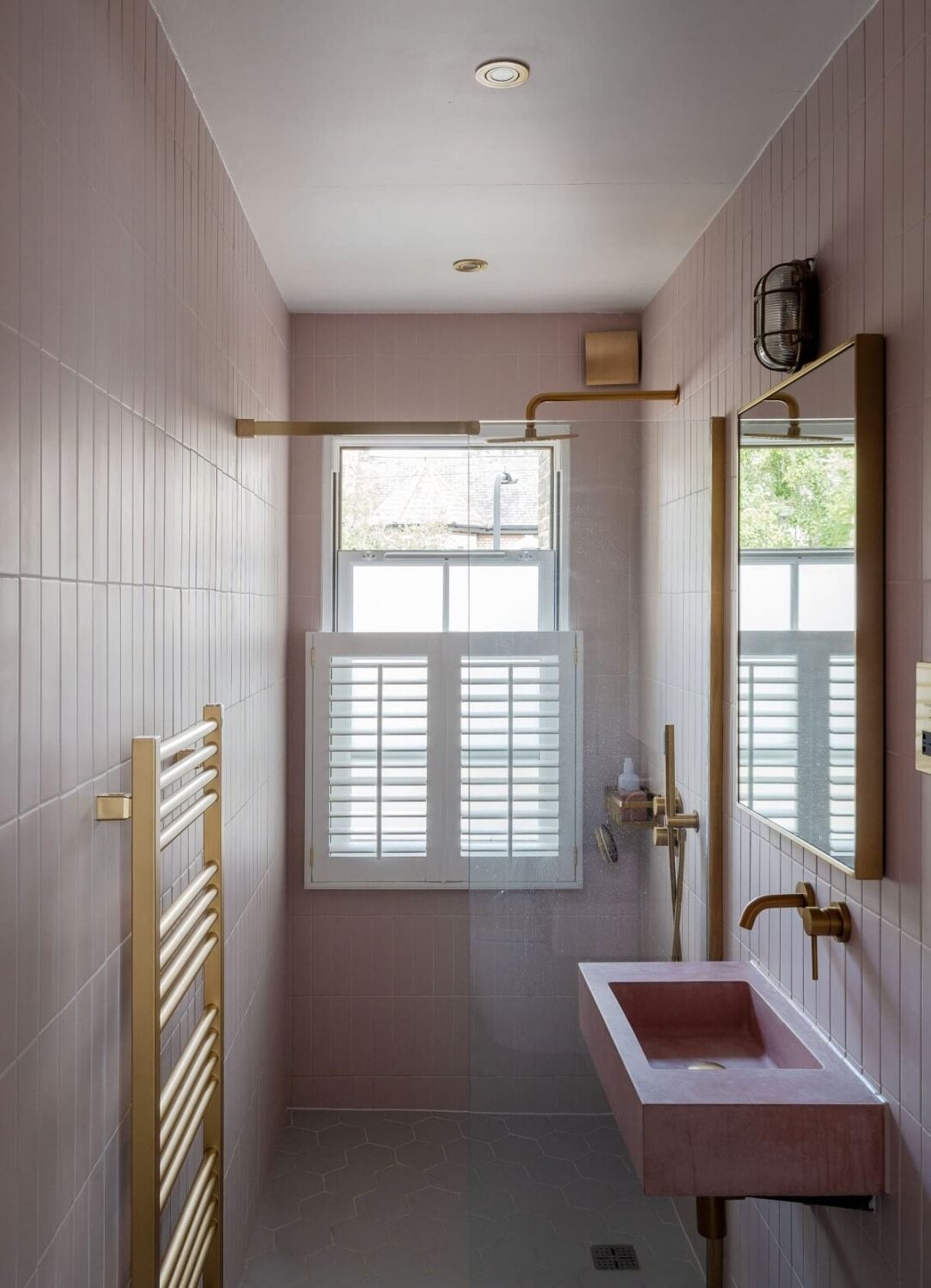 A Stunning Color Palette in an Extended Edwardian House in London 26 small bathroom with pink tiles and sink and brass fittings nordroom